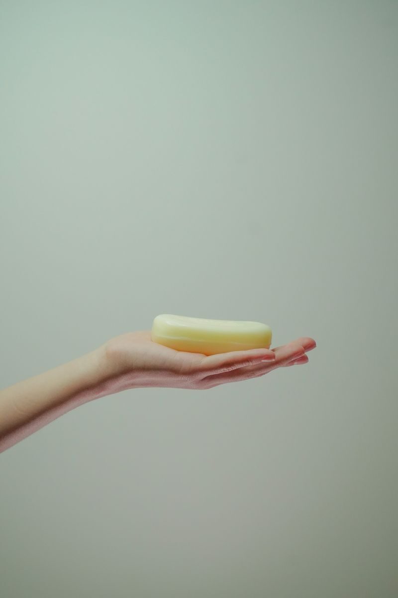 Minimalist image of a hand holding a bar of soap, highlighting hygiene and cleanliness.