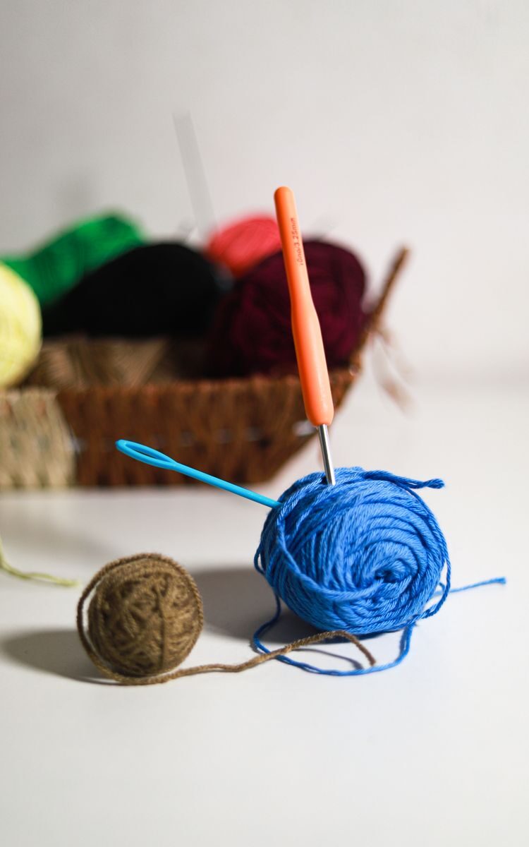 Colorful yarn balls and crochet hooks on a table, perfect for knitting projects.